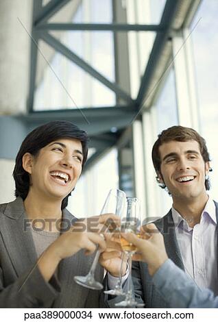 Young executives clinking glasses of champagne and laughing View Large Photo Image Picture - Young executives clinking glasses of champagne and laughing. Fotosearch