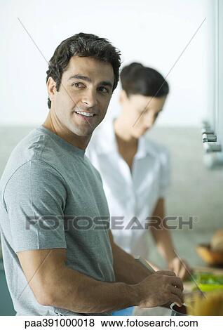 Stock Photo - Couple cooking in kitchen. Fotosearch
