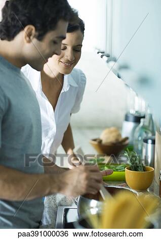 Couple cooking in kitchen View Large Photo Image Stock Photograph - Couple cooking in kitchen. Fotosearch