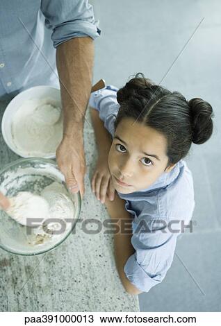 Stock Image - Father and daughter cooking together. Fotosearch