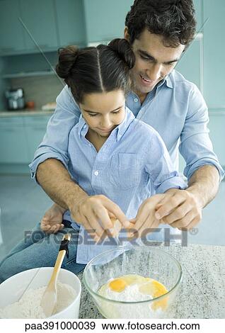 Stock Photo - Father and daughter cooking together. Fotosearch