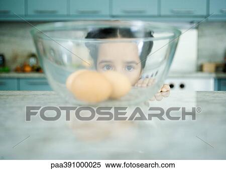 Girl looking through bowl containing eggs View Large Photo Image Stock Photography - Girl looking through bowl containing eggs. Fotosearch