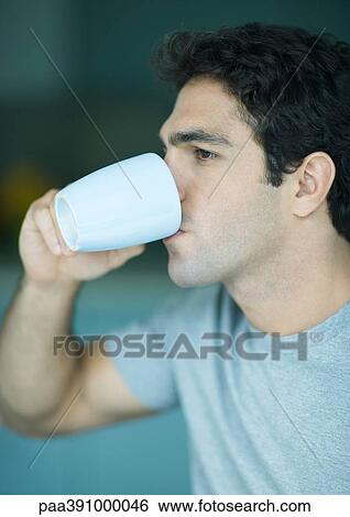 Stock Photograph - Man drinking from mug. Fotosearch
