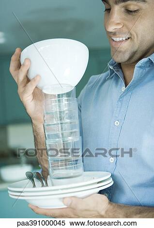 Man holding stack of dishes View Large Photo Image Stock Photography - Man holding stack of dishes. Fotosearch