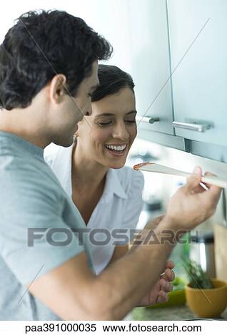 Man holding up wooden spoon for woman to taste View Large Photo Image Stock Photography - Man holding up wooden spoon for woman to taste. Fotosearch