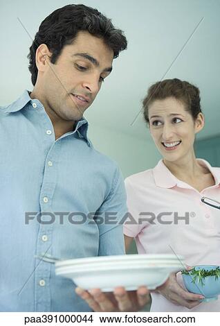 Man looking down at plate, making face, woman looking at him View Large Photo Image Picture - Man looking down at plate, making face, woman looking at him. Fotosearch