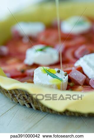 Olive oil being drizzled on uncooked pizza View Large Photo Image Stock Image - Olive oil being drizzled on uncooked pizza. Fotosearch