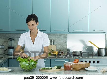 Woman making salad in the kitchen View Large Photo Image Stock Photography - Woman making salad in the kitchen. Fotosearch