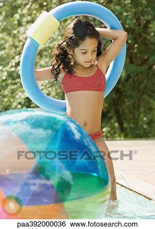 Girl in swimming pool, holding ring over head View Large Photo Image Stock Photograph - Girl in swimming pool, holding ring over head. Fotosearch