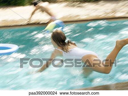 Girl jumping into swimming pool View Large Photo Image Picture - Girl jumping into swimming pool. Fotosearch