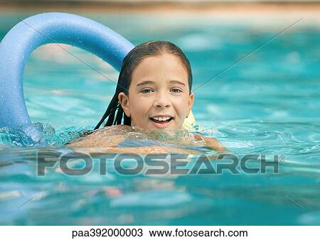 Stock Image - Girl using floating ring in swimming pool. Fotosearch