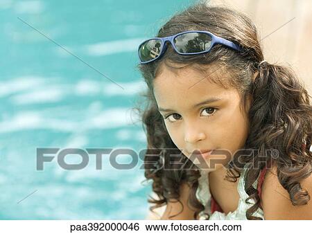 Girl with sunglasses on head, pool in background View Large Photo Image Stock Photograph - Girl with sunglasses on head, pool in background. Fotosearch