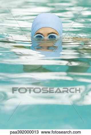 Person in swimming pool wearing bathing cap and goggles View Large Photo Image Stock Image - Person in swimming pool wearing bathing cap and goggles. Fotosearch