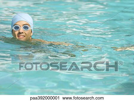 Person wearing bathing cap and goggles in pool View Large Photo Image Stock Image - Person wearing bathing cap and goggles in pool. Fotosearch