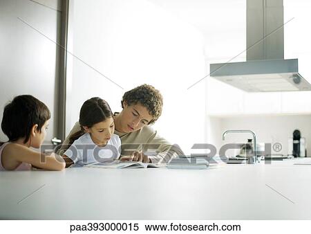 Adolescent boy helping little sister with homework View Large Photo Image Stock Photography - Adolescent boy helping little sister with homework. Fotosearch