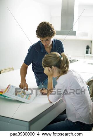 Adolescent boy helping sister with homework View Large Photo Image Picture - Adolescent boy helping sister with homework. Fotosearch