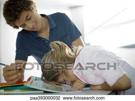 Adolescent boy helping sister with homework, girl's head down on books View Large Photo Image Stock Image - Adolescent boy helping sister with homework, girl's head down on books. Fotosearch