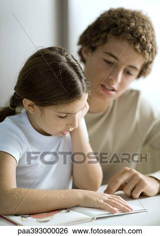 Adolescent boy listening to little sister read View Large Photo Image Stock Photograph - Adolescent boy listening to little sister read. Fotosearch
