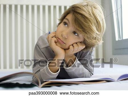 Boy doing homework, looking up View Large Photo Image Stock Photo - Boy doing homework, looking up. Fotosearch
