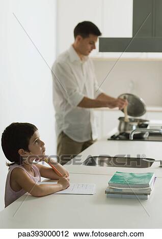 Child doing homework while father cooks meal View Large Photo Image Stock Image - Child doing homework while father cooks meal. Fotosearch