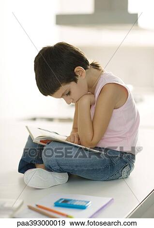 Child sitting on counter reading View Large Photo Image Stock Photo - Child sitting on counter reading. Fotosearch
