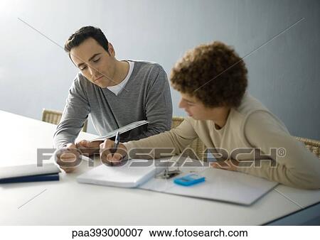 Father helping teenage son with homework View Large Photo Image Stock Photo - Father helping teenage son with homework. Fotosearch