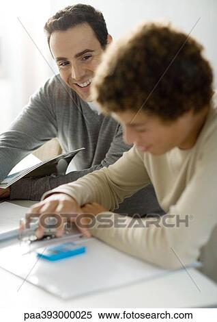 Father helping teenage son with homework View Large Photo Image Stock Photography - Father helping teenage son with homework. Fotosearch