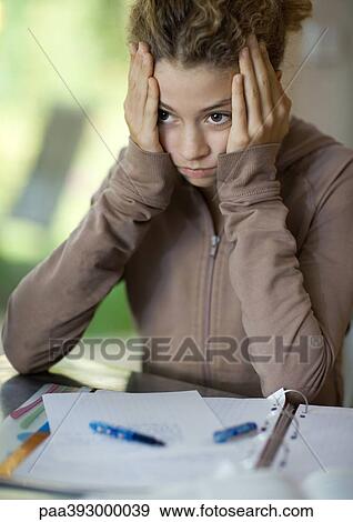 Preteen girl doing homework, holding head View Large Photo Image Stock Photo - Preteen girl doing homework, holding head. Fotosearch