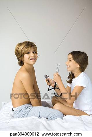 Boy and girl playing with stethoscope View Large Photo Image Stock Image - Boy and girl playing with stethoscope. Fotosearch