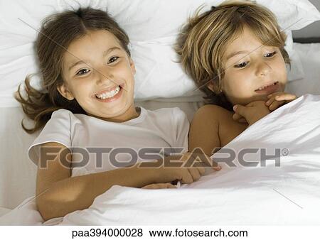 Brother and sister lying in bed together View Large Photo Image Stock Photo - Brother and sister lying in bed together. Fotosearch