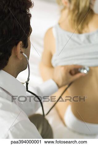 Stock Image - Doctor examining girl with stethoscope. Fotosearch