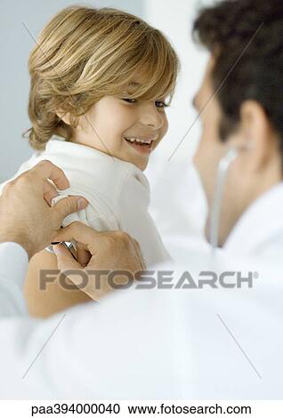 Man examining boy with stethoscope View Large Photo Image Stock Image - Man examining boy with stethoscope. Fotosearch