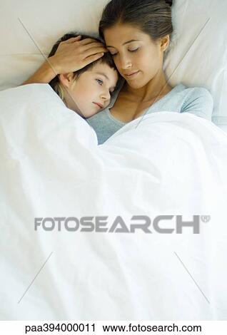 Woman and child lying under covers together View Large Photo Image Stock Image - Woman and child lying under covers together. Fotosearch