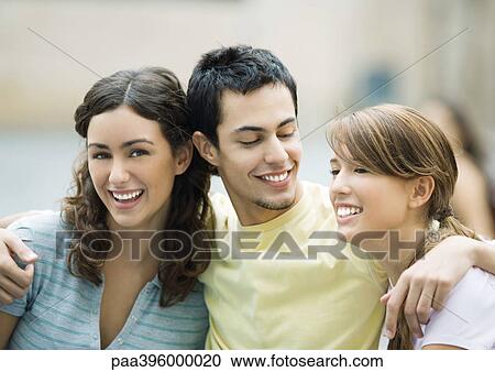 Teen boy with arms around two female friends View Large Photo Image Stock Image - Teen boy with arms around two female friends. Fotosearch