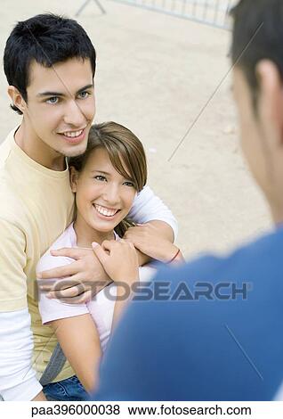 Teen couple looking at friend View Large Photo Image Stock Photo - Teen couple looking at friend. Fotosearch