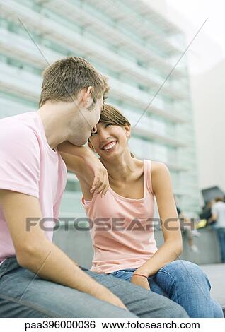 Teen couple sitting in urban area, smiling at each other View Large Photo Image Stock Photograph - Teen couple sitting in urban area, smiling at each other. Fotosearch