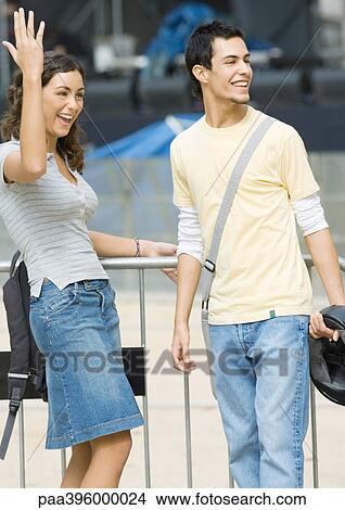 Teen couple smiling and looking out of frame, girl making gesture View Large Photo Image Picture - Teen couple smiling and looking out of frame, girl making gesture. Fotosearch