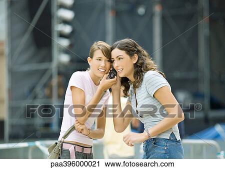Teen girls listening to cell phone together View Large Photo Image Stock Image - Teen girls listening to cell phone together. Fotosearch