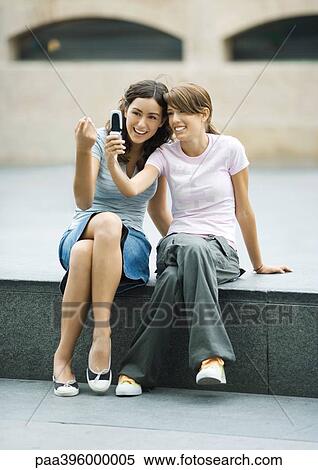 Stock Photography - Teen girls taking photo together with cell phone. Fotosearch