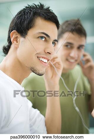 Teen males listening to earphones View Large Photo Image Stock Image - Teen males listening to earphones. Fotosearch