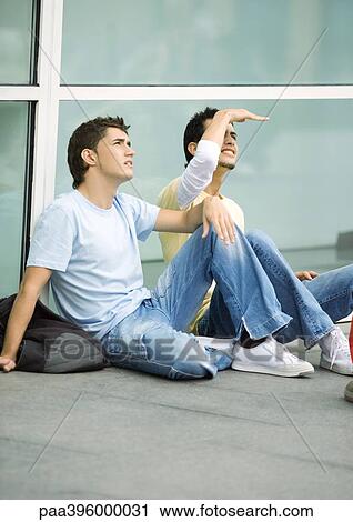 Teen males sitting on ground, looking up View Large Photo Image Stock Image - Teen males sitting on ground, looking up. Fotosearch