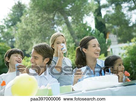 Stock Photograph - Family having outdoor birthday party. Fotosearch