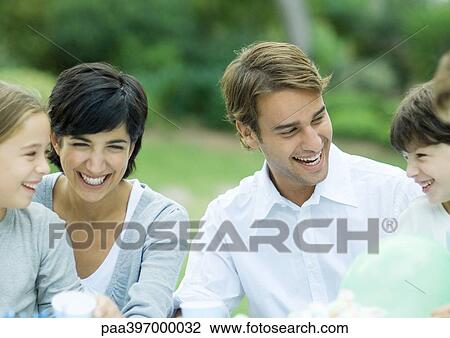 Stock Image - Family laughing, outdoors. Fotosearch