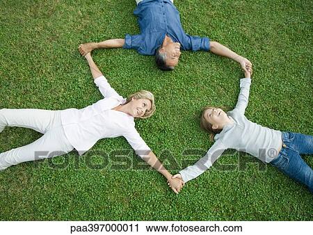 Mature couple and granddaughter lying on grass, holding hands View Large Photo Image Stock Image - Mature couple and granddaughter lying on grass, holding hands. Fotosearch