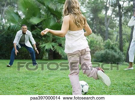 Picture - Mature man playing soccer with granddaughter. Fotosearch