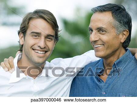 Mature man with arm around shoulder of adult son, smiling View Large Photo Image Stock Photograph - Mature man with arm around shoulder of adult son, smiling. Fotosearch