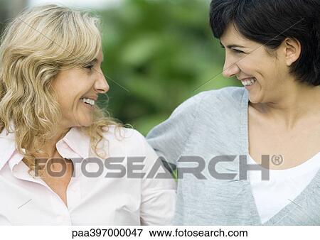 Mature woman and adult daughter, smiling at each other View Large Photo Image Stock Photo - Mature woman and adult daughter, smiling at each other. Fotosearch