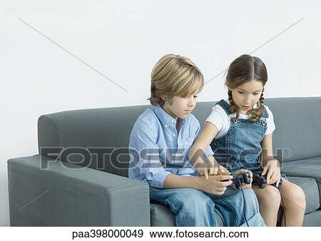 Stock Photo - Girl helping boy with joystick. Fotosearch