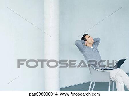 Man sitting with laptop on lap, head back and eyes closed View Large Photo Image Picture - Man sitting with laptop on lap, head back and eyes closed. Fotosearch