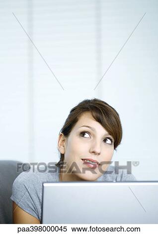 Woman looking up from laptop View Large Photo Image Stock Photography - Woman looking up from laptop. Fotosearch